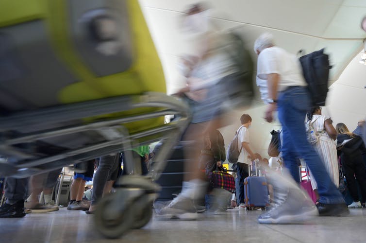 Une photo floue de personnes circulant dans un aéroport